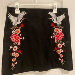 Embroidered leather black mini skirt.